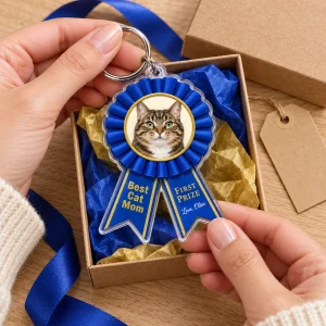 Hands unwrapping the Best Cat Mom Prize Ribbon Keychain from a kraft gift box