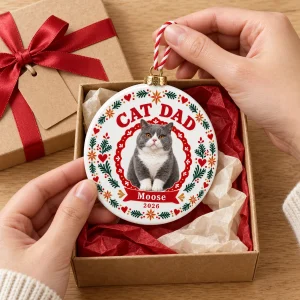 Hands unwrapping the Cat Dad Scandinavian Folk Christmas Ornament from a kraft gift box