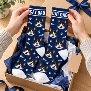 Hands unwrapping the Cat Dad Socks from a kraft gift box