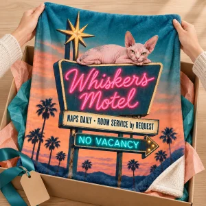 Hands unwrapping the Cat Nap Motel Sign Blanket from a kraft gift box