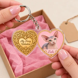 Hands unwrapping the Heart Locket Cat Valentine Keychain from a kraft gift box