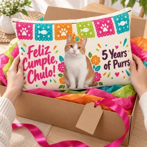 Hands unwrapping the Papel Picado Cat Birthday Lumbar Pillow from a kraft gift box