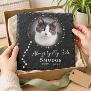Hands unwrapping the Paw Print Path Cat Memorial Slate Plaque from a kraft gift box